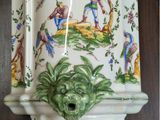 a vase with a green face on it on a shelf