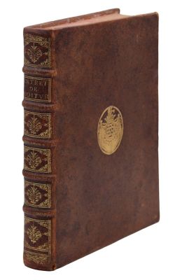 un vieux livre marron orné d'un emblème doré sur la couverture