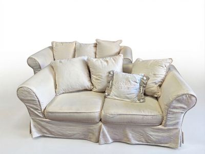 a white couch with pillows on it and a pillow on the back