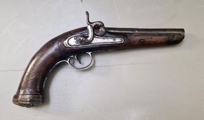 gros plan d'un pistolet sur une table à fond blanc