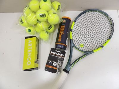une raquette de tennis, des balles de tennis et des piles sur la table