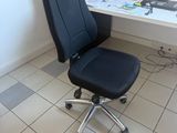 une chaise de bureau noire assise devant un bureau blanc