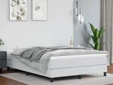 a white bed sitting in a bedroom next to a night stand