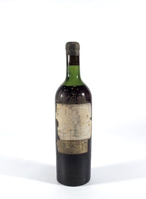 une vieille bouteille de vin posée sur une surface blanche