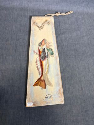 a close up of a bookmark with a fish on it
