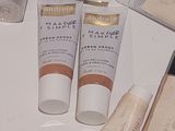 many different types of makeup products on a white table