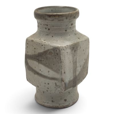 a gray vase that is sitting on a white surface