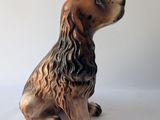 brown and black dog figurine sitting on a white surface