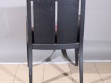 a black chair with a red seat on a tile floor