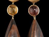 deux paires de boucles d'oreilles en bois et dorées sur fond noir