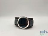 a close up of a watch with a black band and a silver ring