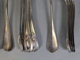 a lot of spoons and forks that are on the table