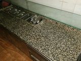 a counter with a sink and a counter top in a kitchen
