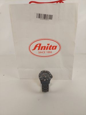 une photo d'une montre posée sur un sac en papier blanc