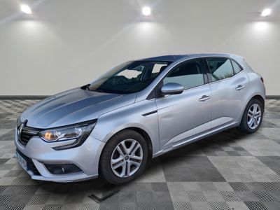 une voiture argentée est garée sur le sol à carreaux d'un garage