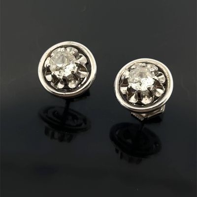 une paire de boucles d'oreilles en diamant sur une surface noire