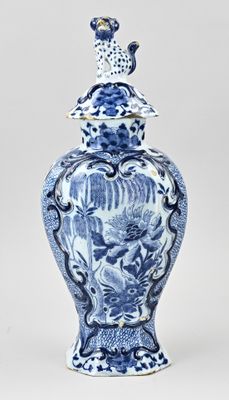 blue and white vase with a bird on top of it