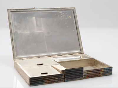 une petite boîte en argent surmontée d'un miroir