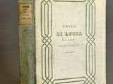 un vieux livre posé sur une table, à côté d'un vase