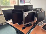 three computer monitors sitting on a desk in a room