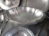 a lot of silverware on a table with silver spoons and forks