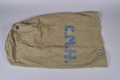 an old brown bag with blue writing on it sitting on a white surface