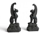 deux sculptures noires représentant un oiseau et un dragon sur un fond blanc