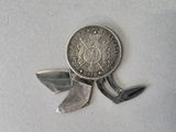 a silver coin and a knife on a white surface