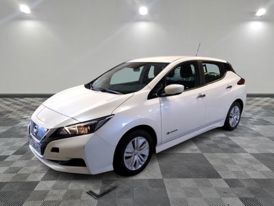 the white nissan leaf is parked on a checkered tile floor