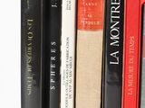 several books are lined up on top of each other on a shelf
