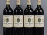 four bottles of wine are lined up on a table
