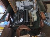 une pile de vieilles machines à écrire et d'autres objets posés sur une table