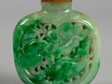 a green glass bottle with a picture of a dragon on it