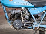 a blue motorcycle parked in front of a brick wall