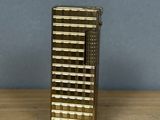 a gold lighter sitting on top of a wooden table