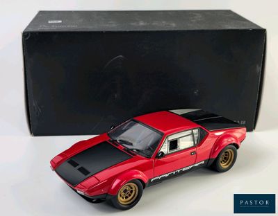 a red toy car that is next to a black box
