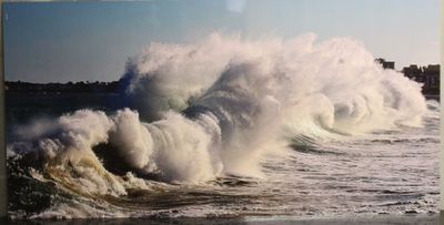 une photo montrant une grosse vague déferlant sur le rivage