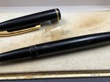 a black pen and a gold pen sitting in a box