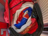 a red and black bag with clothes inside of it
