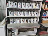 de nombreux pots de peinture posés sur une étagère dans un garage