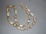 a necklace made of white and brown beads on a gray surface