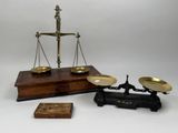 une image représentant une balance sur laquelle est posée une boîte en bois