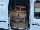 une camionnette blanche dont la porte est ouverte et qui comporte un lit à l'arrière