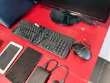 an image of a desk with a computer, keyboard, mouse, and other electronics