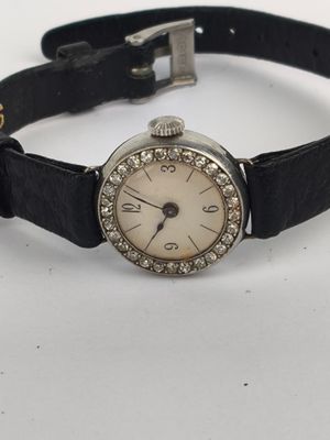 an image of a woman ' s wrist watch on a black leather strap