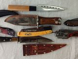 many different types of knives on a white cloth