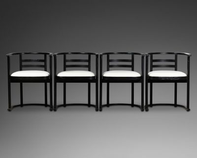 quatre chaises noires avec des coussins blancs sur fond gris