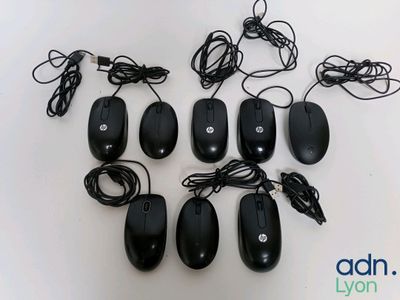 Plusieurs souris d'ordinateur noires sont alignées sur une surface blanche