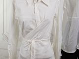 two mannequins dressed in white shirts and black pants in a white room