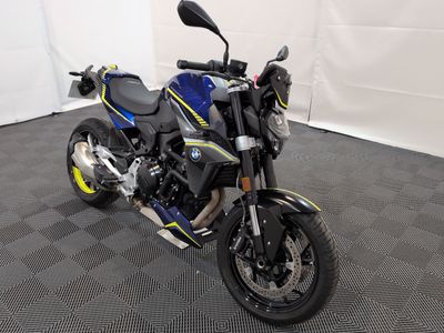 une photo d'une moto bleue et jaune garée dans un garage